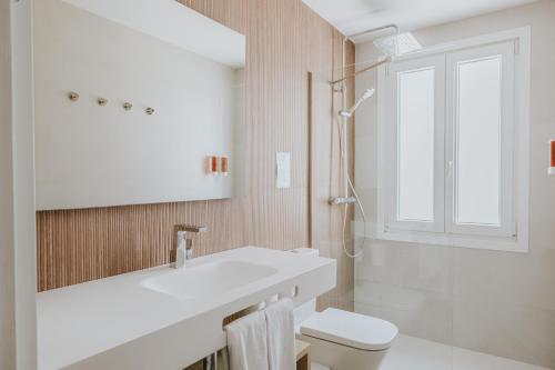 a white bathroom with a sink and a toilet at Villa Santo Tomas - Gabriela in Santo Tomás