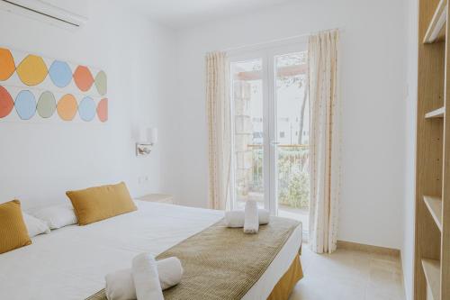 a white bedroom with a large bed and a window at Villa Santo Tomas - Gabriela in Santo Tomás