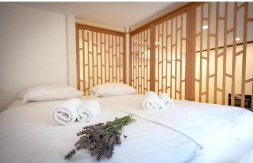 a white bed with towels and flowers on it at Blue Bay Apartment Piran in Piran