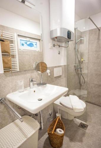 a bathroom with a sink and a toilet and a shower at Blue Bay Apartment Piran in Piran