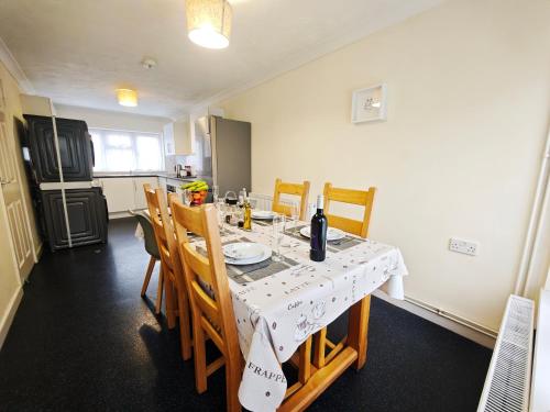 a dining room with a table and chairs and a kitchen at Comfort Private Rooms in Three bedroom House in Bridgemary