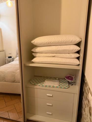 a closet with a stack of pillows and a mirror at Dimora dei cesari in Città di Castello