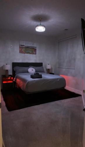 a bedroom with a bed and two lamps and a projector at The 513 Flat! 1BR, 1Bath Apt with Pool and Riverfront View! Free Gated Parking! Only Steps from The banks & Stadiums! in Cincinnati