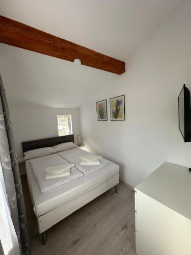 a bedroom with a bed in a white room at CosAlpin Apartament in Cîrlibaba