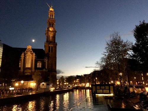 a church with a clock tower and a river at night at Prince Royal B&B in Amsterdam