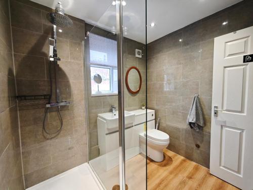a bathroom with a toilet and a glass shower at Comfort Private Rooms in Three bedroom House in Bridgemary