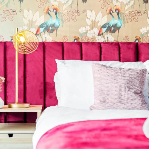 a bed with a pink head board with a pink headboard at Stylish 3 Bedroom House - King Size Beds - 5 Guests - Garden & Parking 4VC in Minworth