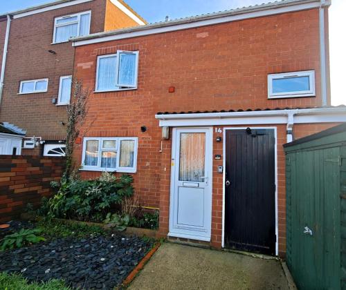 a brick house with a white door and a green gate at Comfort Private Rooms in Three bedroom House in Bridgemary