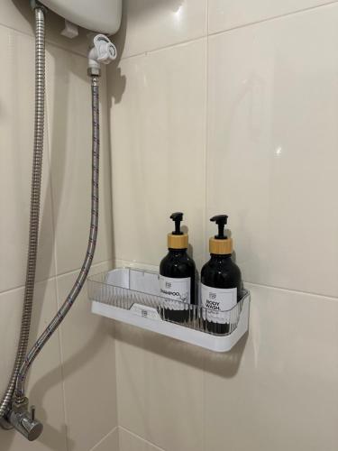 a bathroom with two shampoo bottles on a shelf at Febb x Vintage Room in Ban Ko Takhian