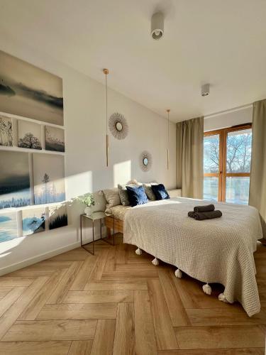 a bedroom with a large bed and a couch at Rudnickiego, Fort Bema, free parking by Cosmo Spirit in Warsaw