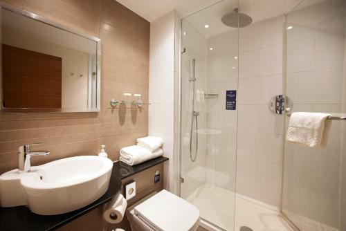 a bathroom with a sink toilet and a shower at Thistle London Piccadilly in London
