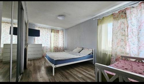 a bedroom with two beds and a window with curtains at 1 комнатная квартира, левый берег, Пр Калнышевского, пр Слобожанский, 6 городская клиника in Nizhnedneprovsk