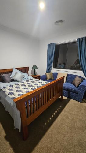 a bedroom with a bed and a chair and a window at Ahvenbloem Park in Kelso