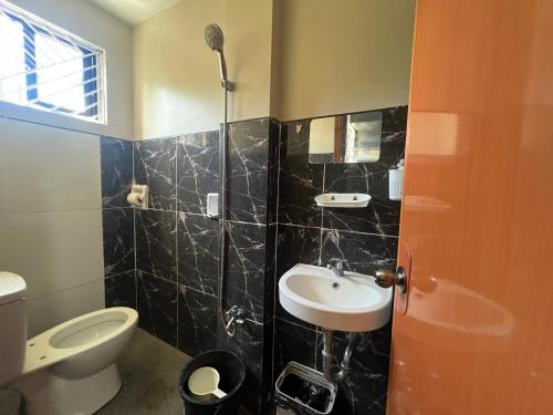 a bathroom with a toilet and a sink at Hayat Apartment Digos City in Dawis