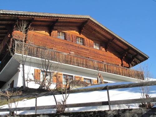 a building with a wooden roof with a statue in front at Apartment Steirösli 1- & 2- Stock by Interhome in Lenk