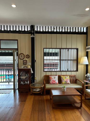 a living room with a couch and a table at Febb x Vintage Room in Ban Ko Takhian