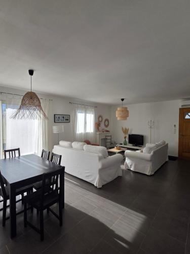 a living room with two white couches and a table at maison être mer et montagne in Ponte-Leccia