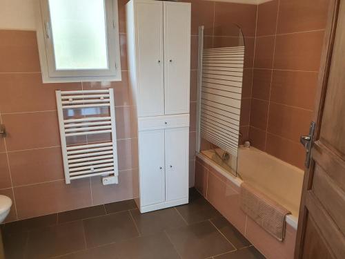 a bathroom with a white cabinet and a sink and a tub at maison être mer et montagne in Ponte-Leccia