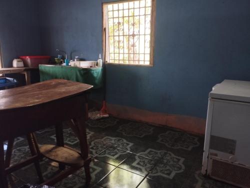 a blue room with a table and a window at Rancho Belen in Isla de Ometepe