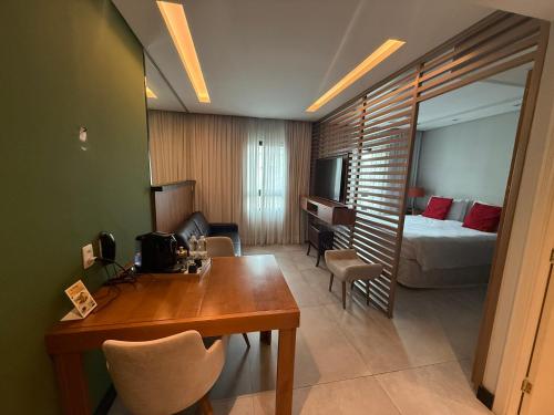 a hotel room with a bed and a desk and a bedroom at Dream Flat Pinheiros in São Paulo