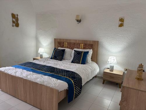 a bedroom with a large bed with blue and white pillows at Casa Madame Aïcha in Sousse
