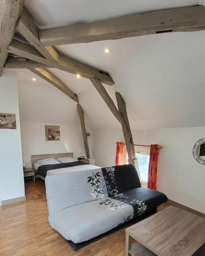 a living room with a couch and a bed at Ma Location Saisonnière in Chasseneuil-du-Poitou