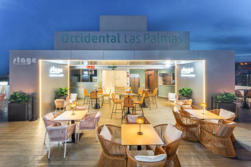a restaurant with tables and chairs in front of a building at Occidental Las Palmas in Las Palmas de Gran Canaria