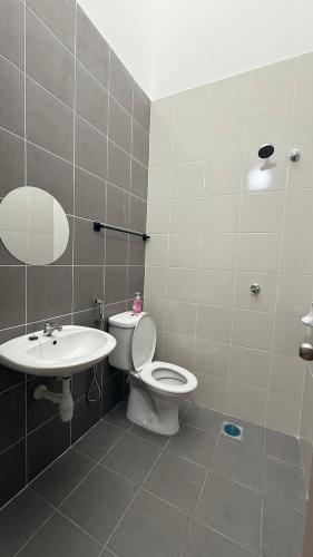 a bathroom with a toilet and a sink at Homestay Azizi in Seri Iskandar