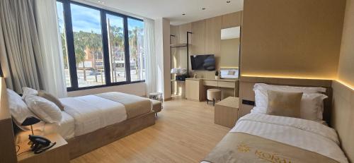 a hotel room with two beds and a large window at Koral Boutique Hotel in Durrës