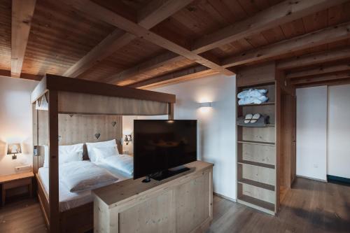 a bedroom with a bunk bed with a large television at Zin Senfter Residence in San Candido