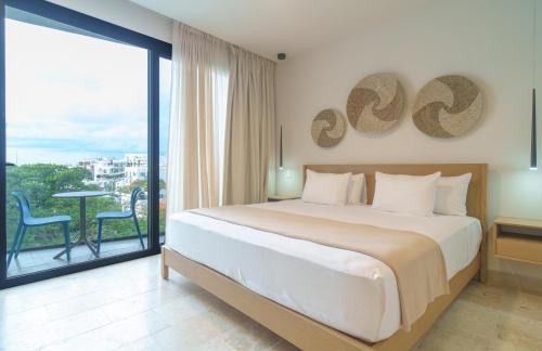 a bedroom with a large bed and a large window at abba Suites Playa del Carmen in Playa del Carmen