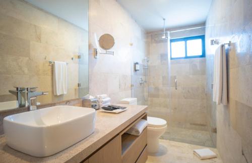 a bathroom with a sink and a toilet and a shower at abba Suites Playa del Carmen in Playa del Carmen