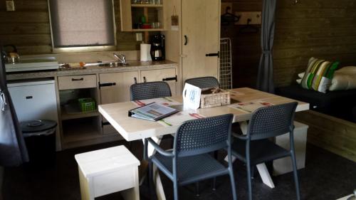 a small kitchen with a table with chairs and a sink at 5 persoons lodge in Witmarsum