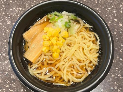 a bowl of noodles with corn and green onions at 2025 RENEWAL OPEN Anshin oyado Nagoya Man & Woman Sakae Station in Nagoya
