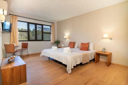 a hotel room with a bed and a television at The Pines Hotel in Culla