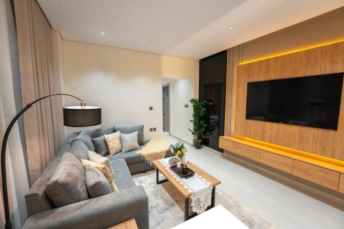 a living room with a couch and a flat screen tv at Luxury & Modern Brand New Family Apartments in Medina