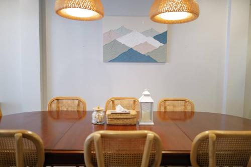 a dining room table with chairs and two lights at My happy place in CNX in Chiang Mai