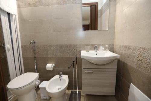 a bathroom with a toilet and a sink at Pianofilecciarooms in Salemi