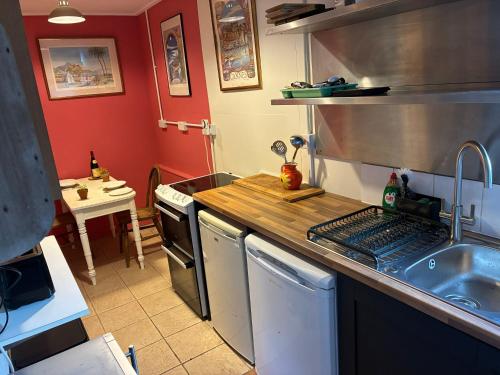 a kitchen with a sink and a stove top oven at Crockers Farm in Dorking