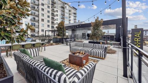 a rooftop patio with couches and a fire pit at Sentral SoBro in Nashville