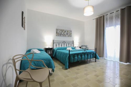 a bedroom with a green bed and a chair at Pianofilecciarooms in Salemi