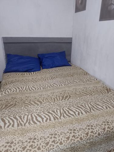 a bed with a blue pillow on top of it at hospedagem com passeio de quadriciclo in Guapimirim