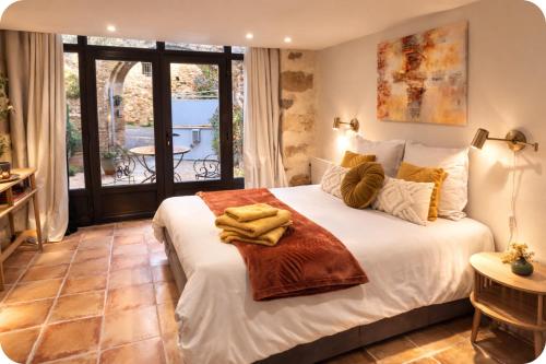 a bedroom with a bed with towels on it at La Parenthèse, chambres d'hôtes in Rochegude