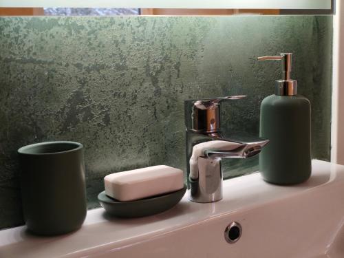 a bathroom sink with a soap dispenser and a faucet at Forest house with outdoor hot tub in Jūrmala
