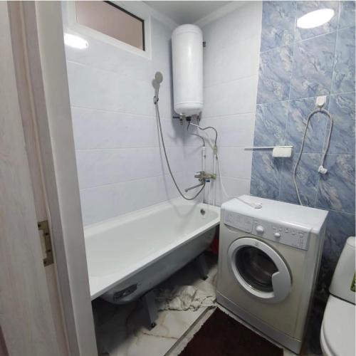 un bagno con lavatrice e lavatrice di Квартира a Karakol