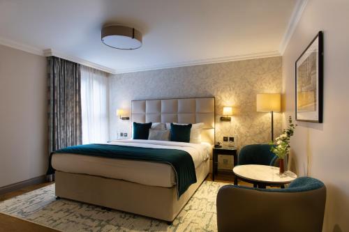 a hotel room with a bed and a chair at The Rathbone Hotel, Fitzrovia in London