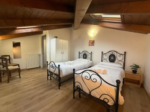 a bedroom with two beds and a chair at Nuvola di Parma// del Ducato 1 in Parma