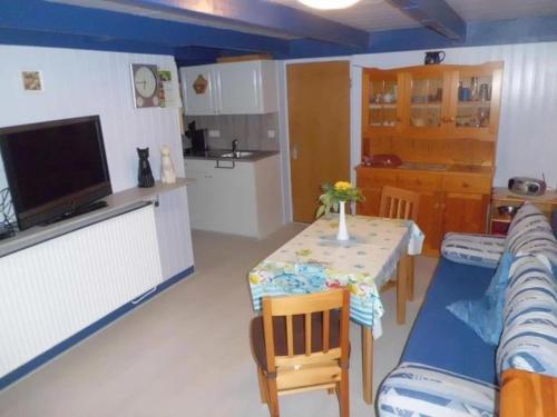 a kitchen and a living room with a table and a couch at Haus Glück Auf in Dornumergrode