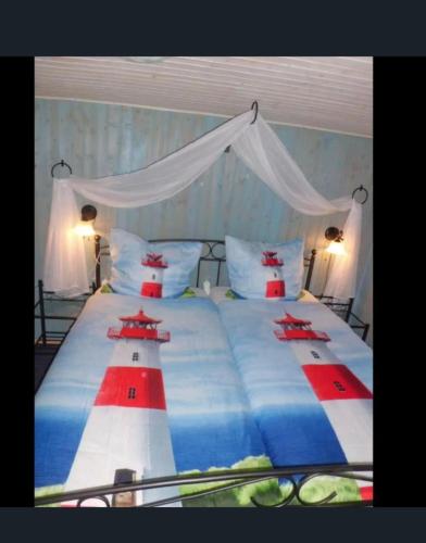 a bedroom with a large bed with red white and blue at Haus Glück Auf in Dornumergrode