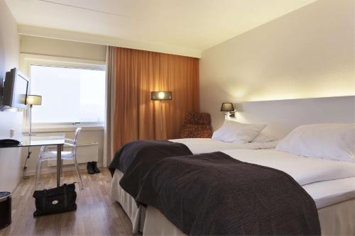 Scandic Alta في ألتا: غرفة فندق بها سريران ومكتب ونافذة